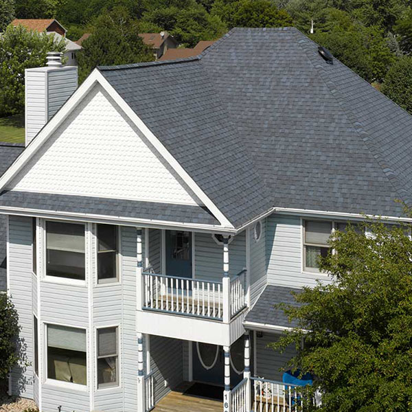 Front view of residential home with white siding and gray CertainTeed shingles on its roof