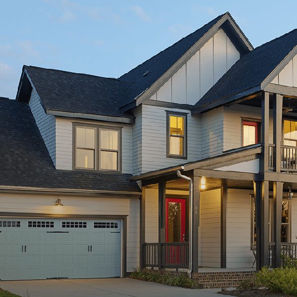 Front view of residential home gray Mastic siding and black shingles on its roof