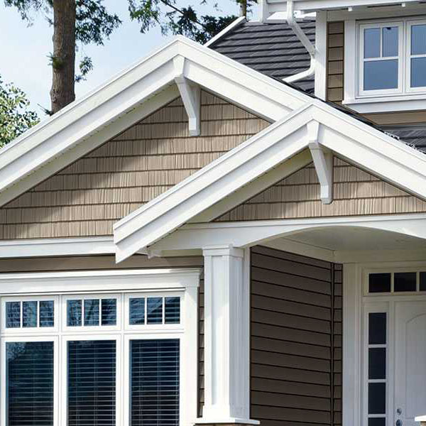 Close-up of the front of a residential home with light brown Norandex siding